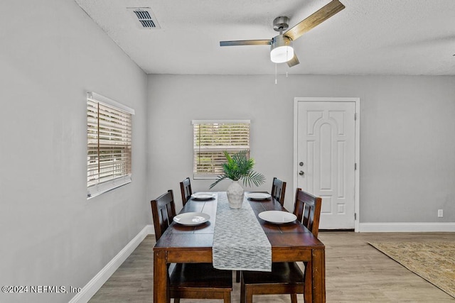 dining area featuring ceiling fan, a textured ceiling, and hardwood / wood-style flooring