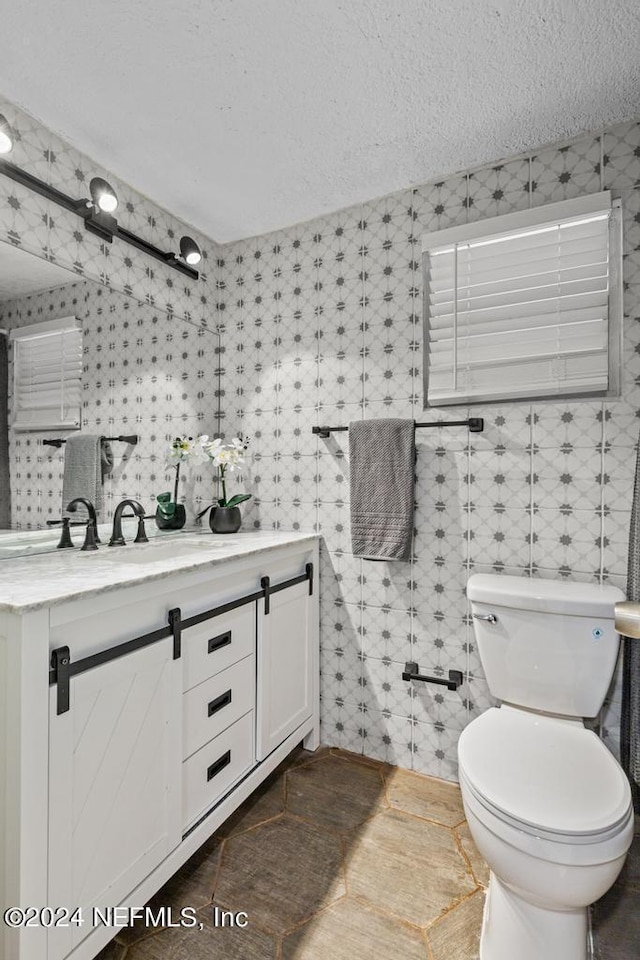 bathroom with vanity, a textured ceiling, toilet, and tile patterned flooring