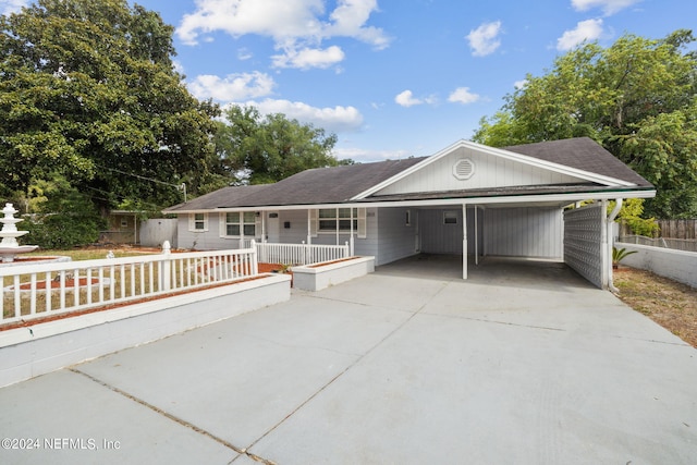 ranch-style home featuring a carport and covered porch