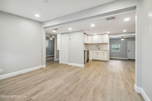 unfurnished living room featuring light hardwood / wood-style flooring and sink