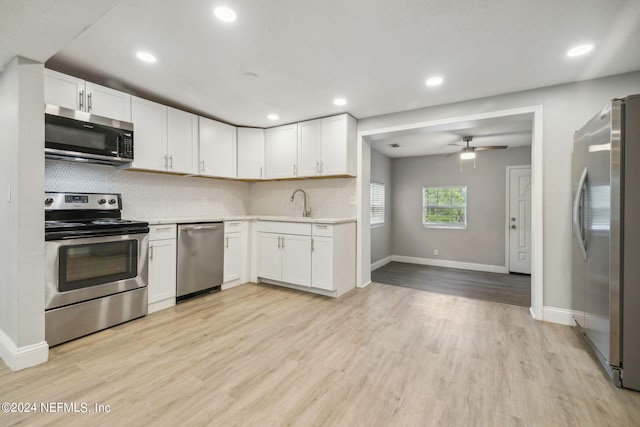 kitchen featuring white cabinets, decorative backsplash, ceiling fan, and appliances with stainless steel finishes