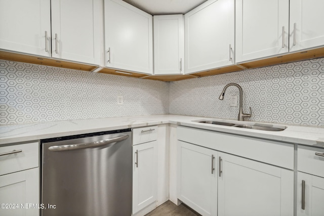 kitchen featuring stainless steel dishwasher, decorative backsplash, white cabinets, and light stone countertops