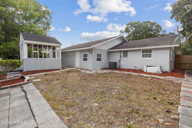 back of house with a lawn and cooling unit