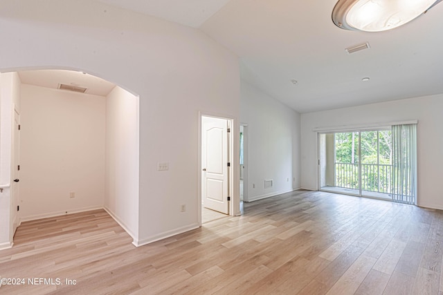 unfurnished room with light hardwood / wood-style floors and vaulted ceiling