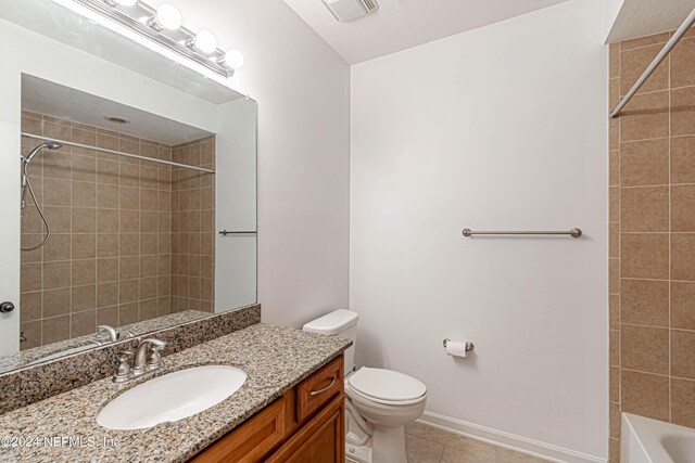 full bathroom with tile patterned floors, toilet, vanity, and tiled shower / bath combo