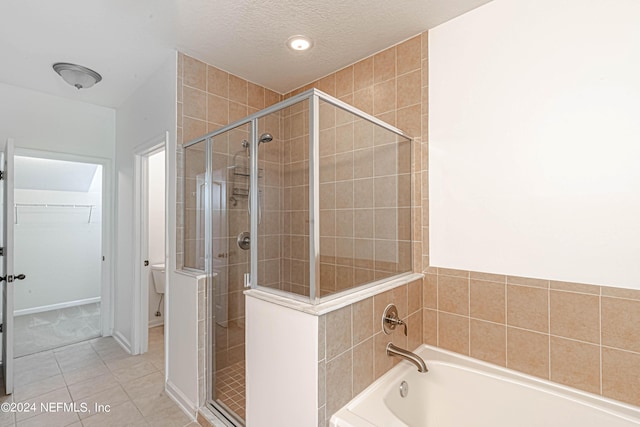 bathroom featuring a textured ceiling, toilet, shower with separate bathtub, and tile patterned flooring