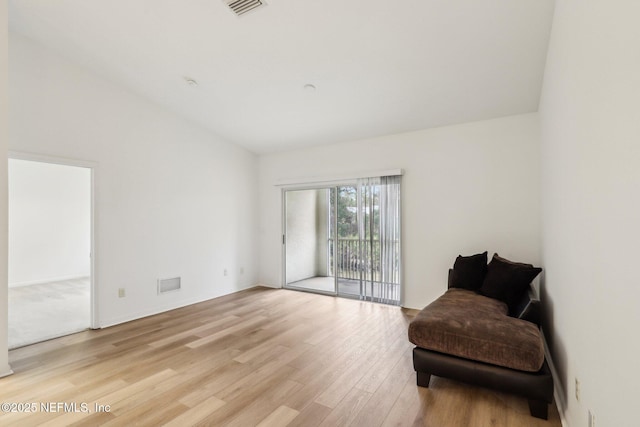 sitting room featuring light hardwood / wood-style floors and lofted ceiling