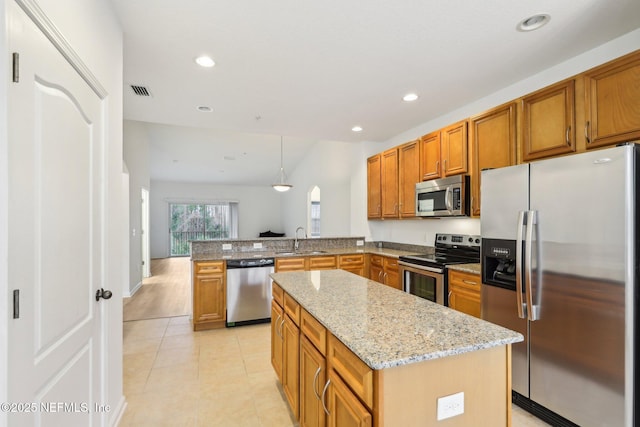 kitchen featuring a center island, appliances with stainless steel finishes, sink, decorative light fixtures, and kitchen peninsula