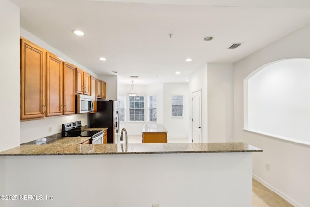 kitchen with appliances with stainless steel finishes, sink, decorative light fixtures, kitchen peninsula, and light stone counters