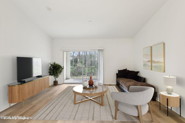 living room with light wood-type flooring and lofted ceiling