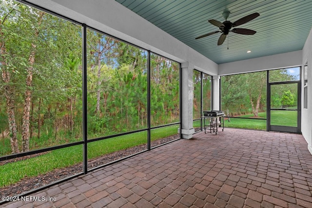 unfurnished sunroom featuring ceiling fan