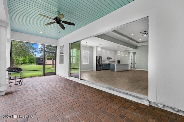 unfurnished sunroom with ceiling fan