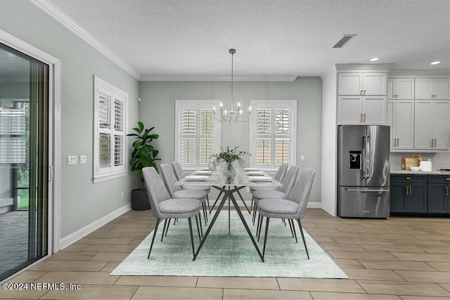 dining area featuring a notable chandelier, crown molding, and a textured ceiling