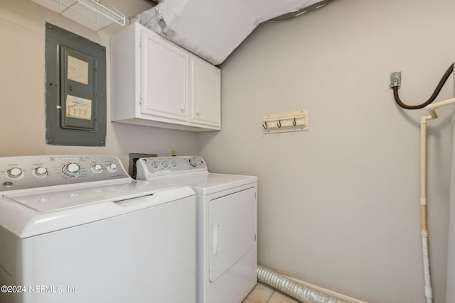 clothes washing area featuring light tile patterned flooring, cabinets, washing machine and dryer, and electric panel