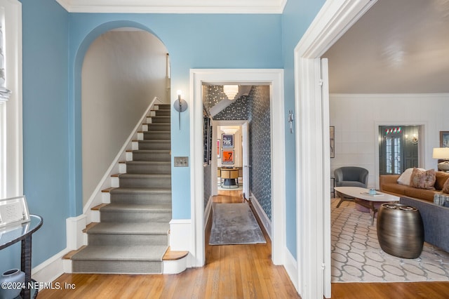 stairway featuring crown molding and light hardwood / wood-style flooring