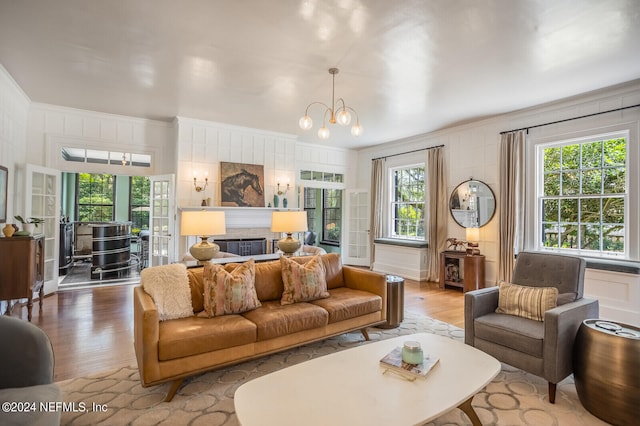 living room with a wealth of natural light, hardwood / wood-style flooring, and an inviting chandelier