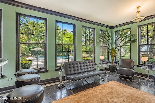 interior space with a healthy amount of sunlight, dark tile floors, and crown molding