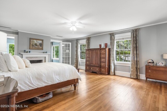 bedroom featuring ceiling fan, light wood-type flooring, and crown molding