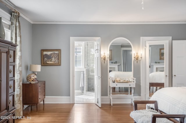 bedroom with ornamental molding, connected bathroom, and hardwood / wood-style floors