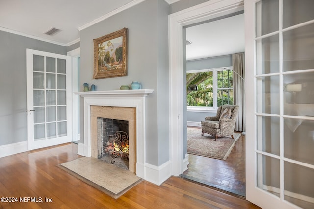 unfurnished living room with hardwood / wood-style floors, a high end fireplace, french doors, and crown molding