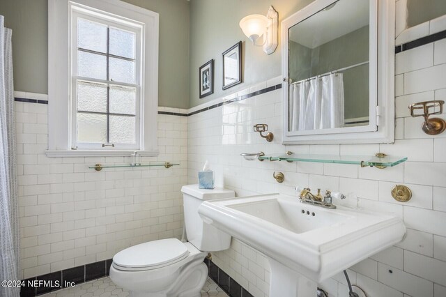 bathroom featuring tile walls, tile flooring, and toilet