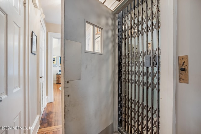 hallway with hardwood / wood-style floors