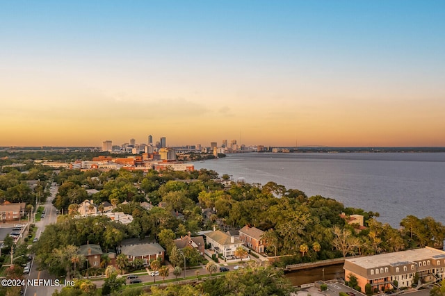 aerial view at dusk featuring a water view