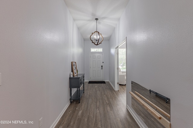 entrance foyer with an inviting chandelier and dark hardwood / wood-style flooring