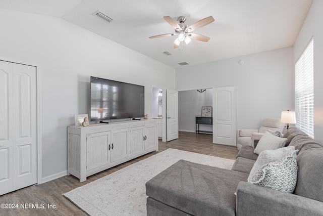 living room featuring ceiling fan, light hardwood / wood-style floors, and lofted ceiling