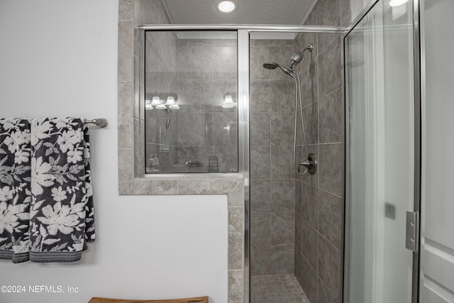 bathroom featuring a shower with shower door and a textured ceiling