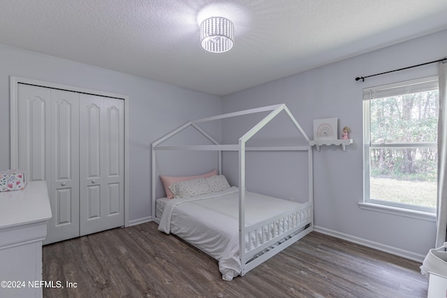 bedroom featuring a closet, hardwood / wood-style floors, and multiple windows