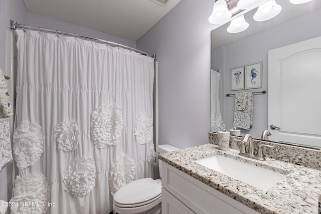 bathroom with a textured ceiling, toilet, and vanity