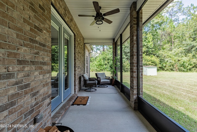 unfurnished sunroom featuring ceiling fan