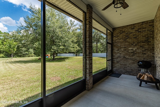 unfurnished sunroom with ceiling fan