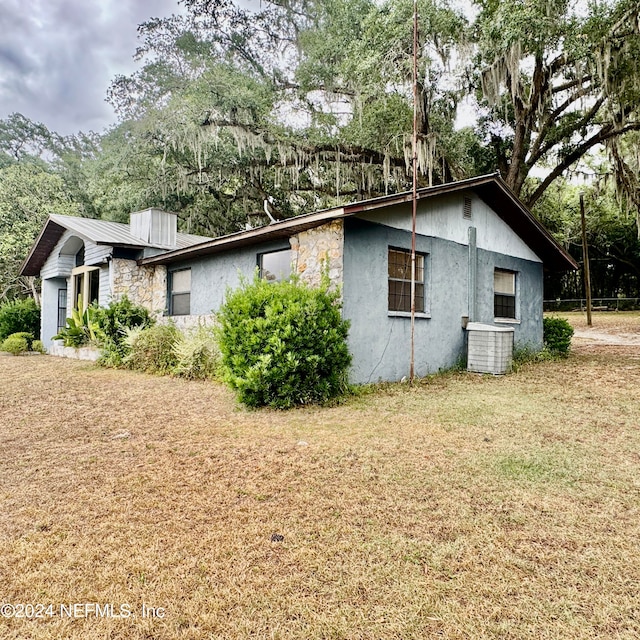 view of property exterior featuring a yard and central AC unit