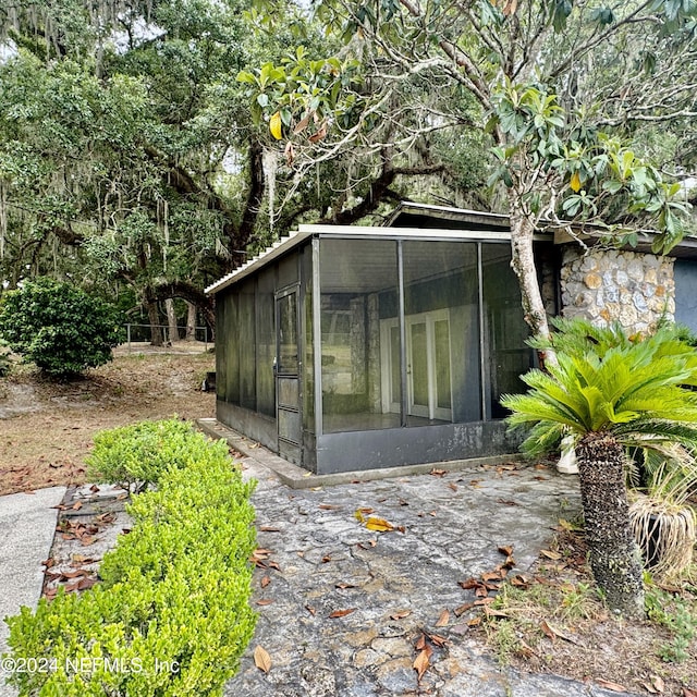 view of outdoor structure featuring a sunroom