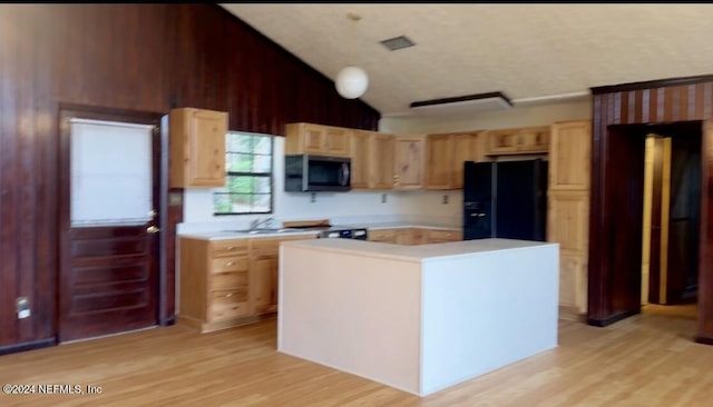 kitchen featuring light countertops, light brown cabinets, black fridge with ice dispenser, and stainless steel microwave