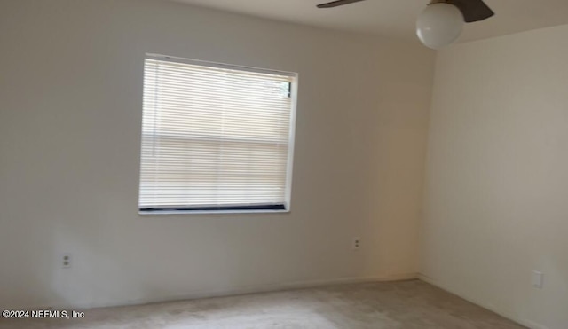 carpeted spare room featuring a ceiling fan