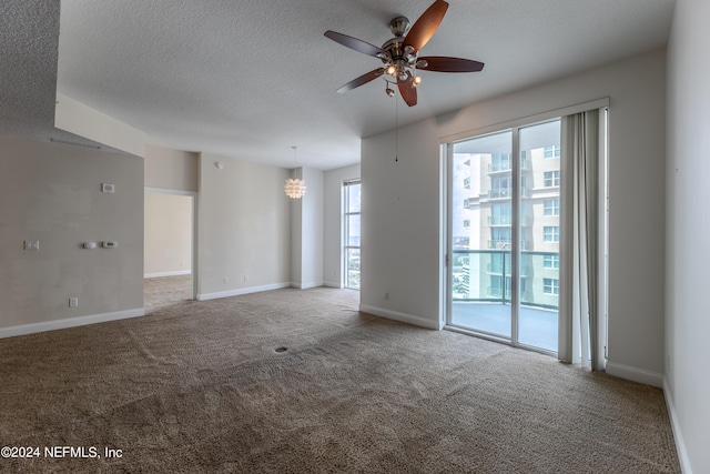 spare room featuring ceiling fan with notable chandelier, a textured ceiling, and light carpet