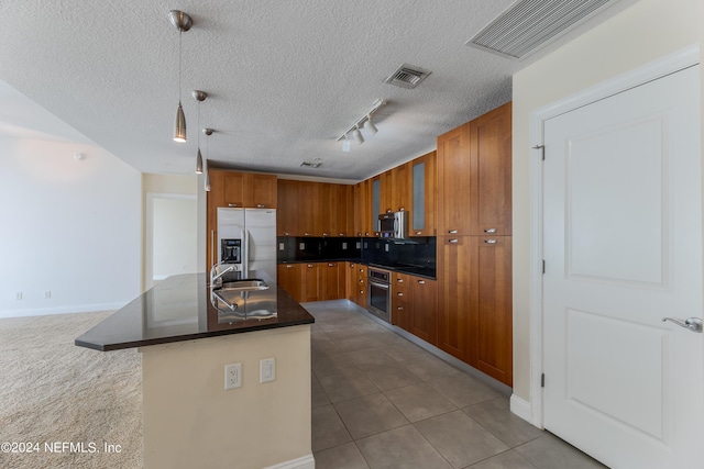 kitchen with stainless steel appliances, sink, a textured ceiling, light tile patterned floors, and pendant lighting