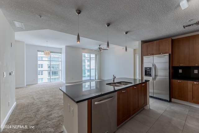 kitchen featuring light carpet, appliances with stainless steel finishes, ceiling fan, sink, and decorative light fixtures