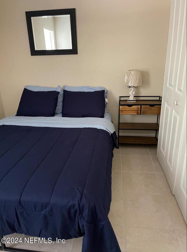 tiled bedroom featuring a closet