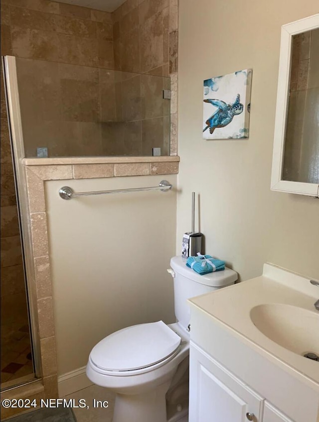 bathroom featuring tile patterned flooring, vanity, toilet, and a shower with shower door