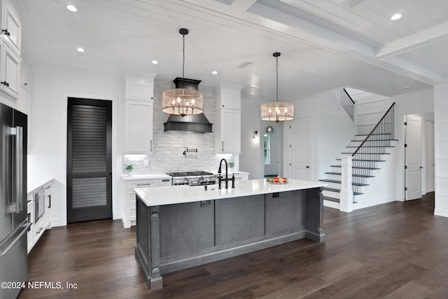 kitchen featuring a center island with sink, white cabinetry, an inviting chandelier, and decorative light fixtures