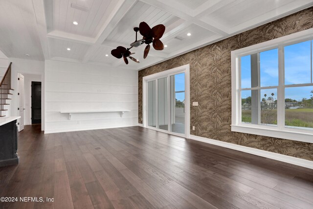 unfurnished living room with a wealth of natural light, beamed ceiling, and dark hardwood / wood-style floors