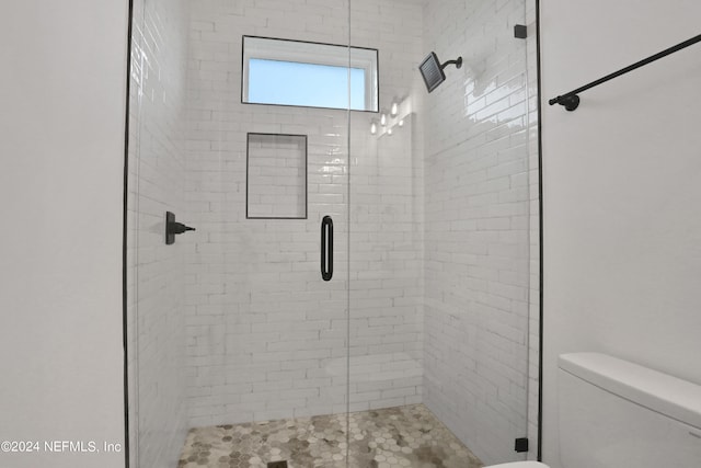 bathroom with toilet and an enclosed shower