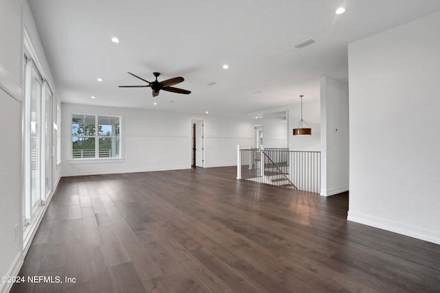 unfurnished living room featuring ceiling fan and dark hardwood / wood-style floors