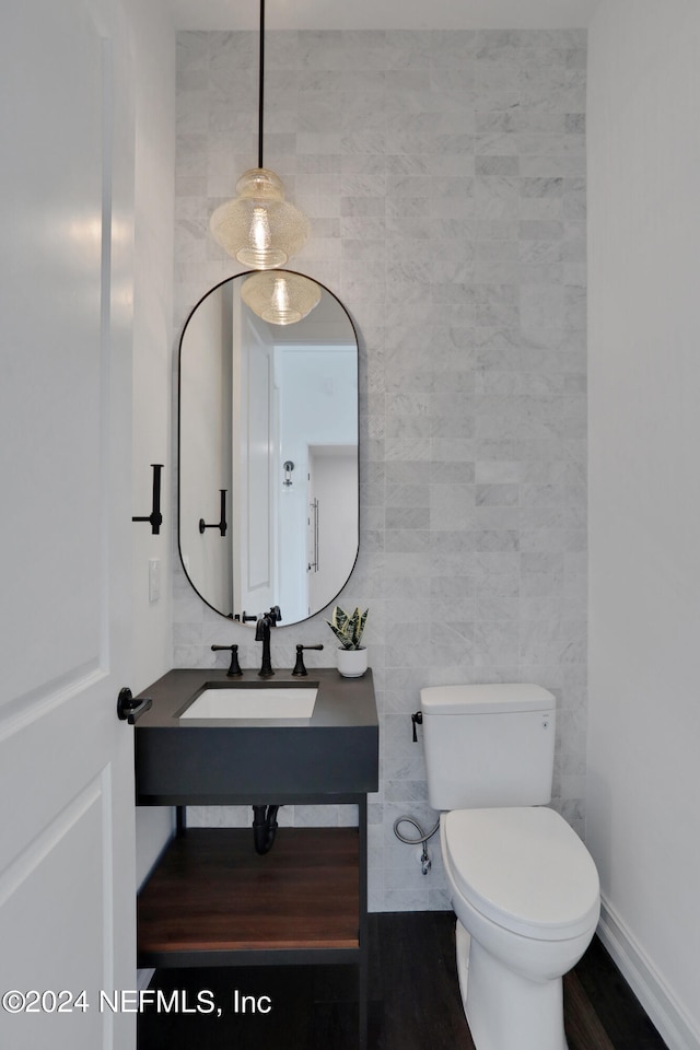 bathroom featuring tile walls, sink, hardwood / wood-style flooring, and toilet