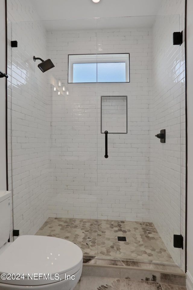 bathroom featuring walk in shower and toilet