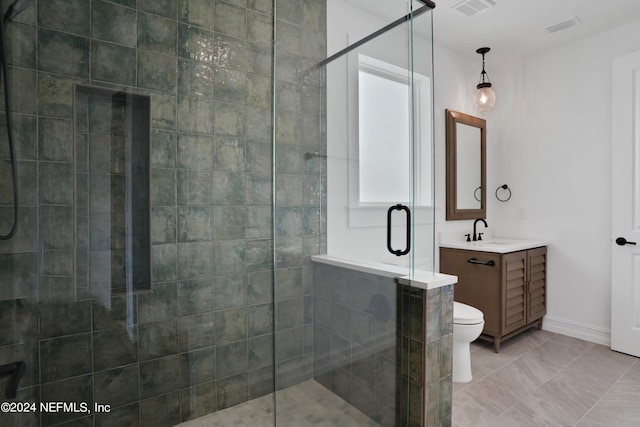 bathroom featuring vanity, tile patterned flooring, toilet, and a shower with door